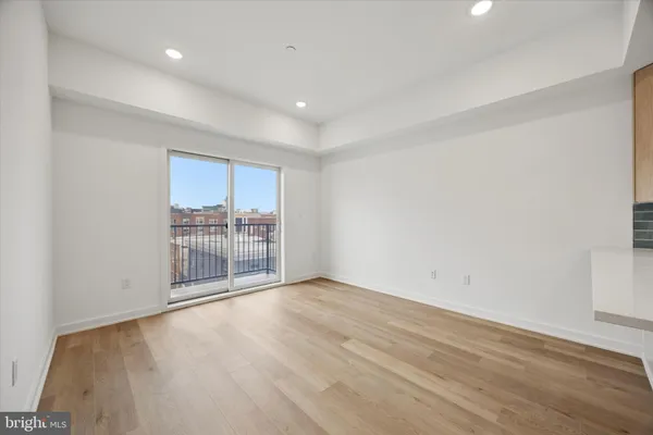a view of a room with wooden floor and a window
