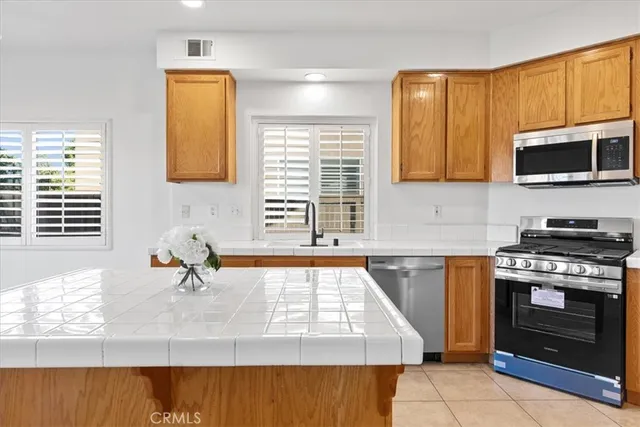 a kitchen with stainless steel appliances granite countertop a sink a stove and a refrigerator
