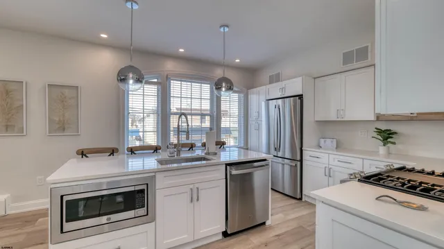 a kitchen that has a sink stainless steel appliances a counter space and a window