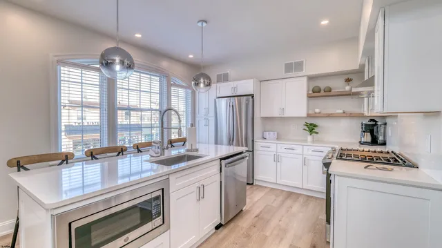 a kitchen that has a lot of cabinets in it and wooden floors