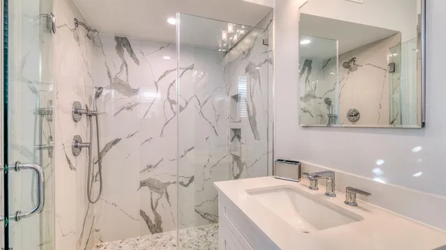 a bathroom with a sink vanity granite shower and a mirror