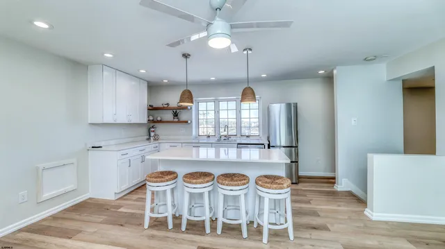 a kitchen with stainless steel appliances granite countertop a dining table chairs and sink