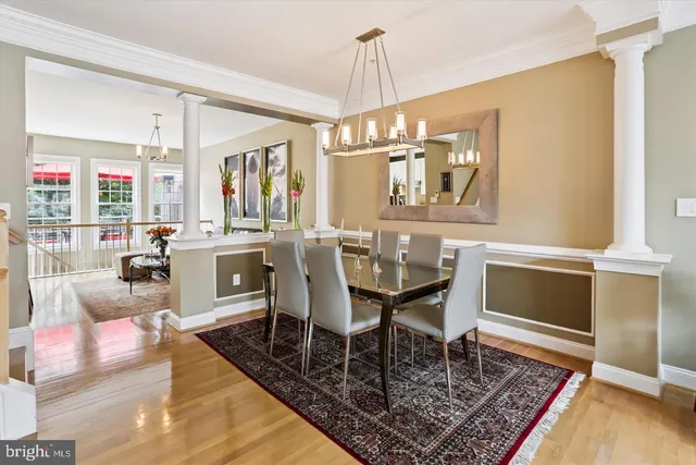 a dining room with wooden floor a chandelier a wooden table and chairs