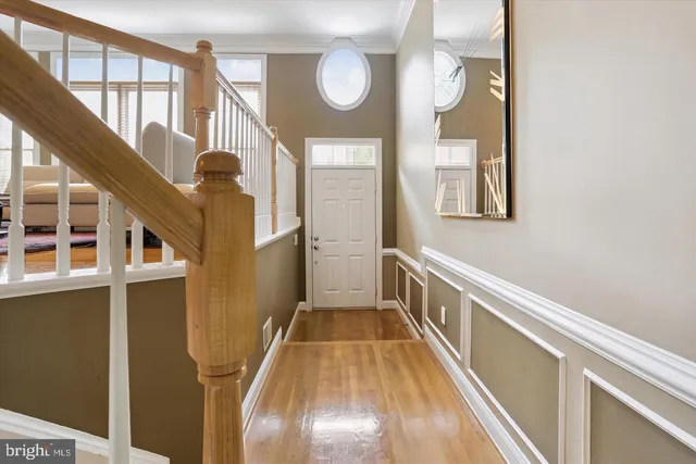 a view of staircase with lots of frames on wall and a window