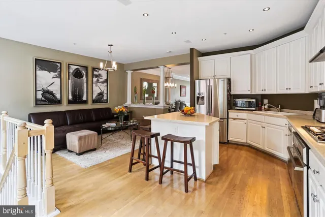 a kitchen with stainless steel appliances granite countertop a refrigerator a stove top oven and white cabinets