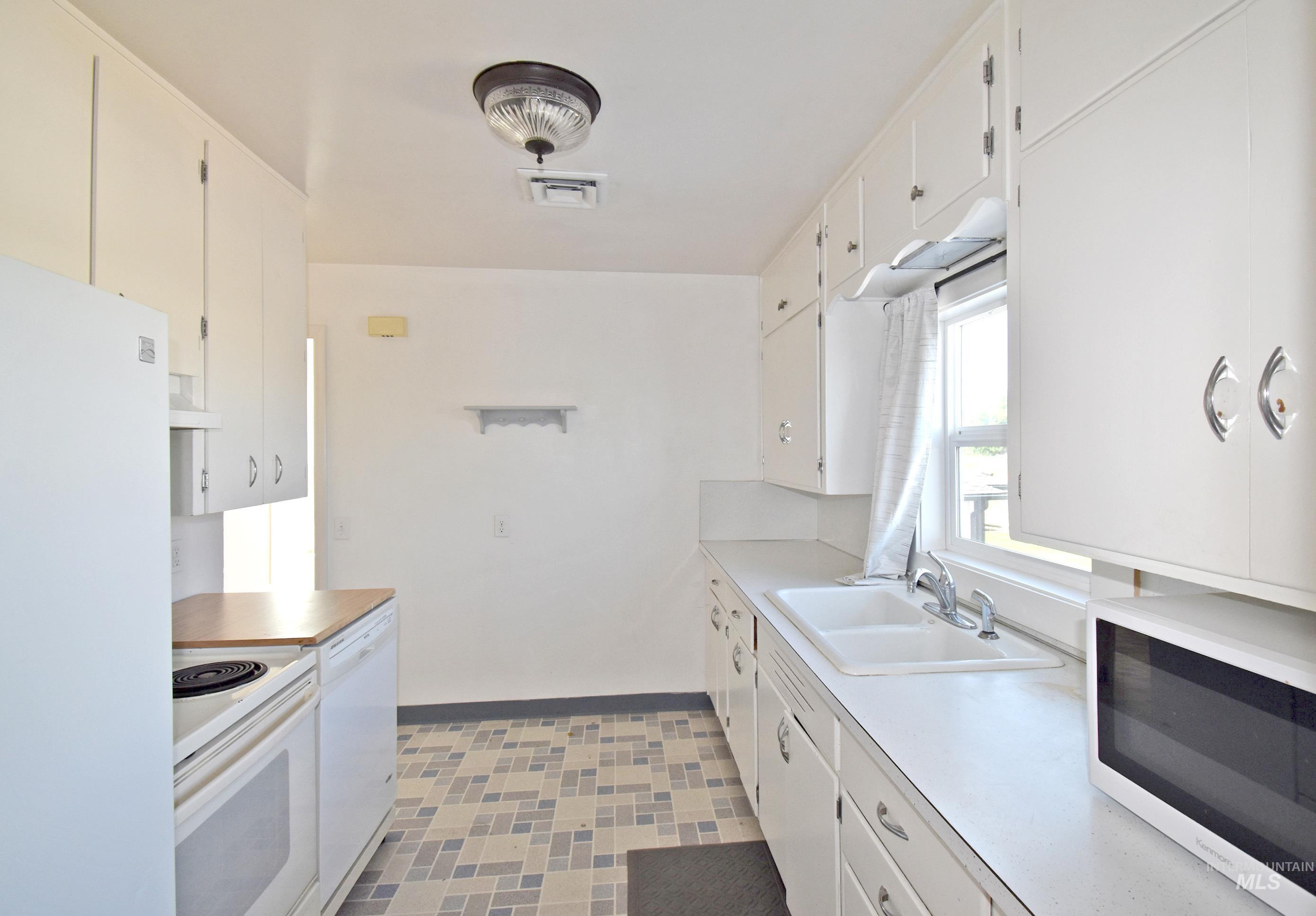 2342-2344 19th Street Clarkston, WA 99403 - Photo 11 of 47 Kitchen with white appliances, exhaust hood, light countertops, and white cabinets