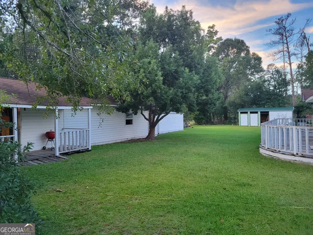 a view of a backyard with a small cabin and wooden fence