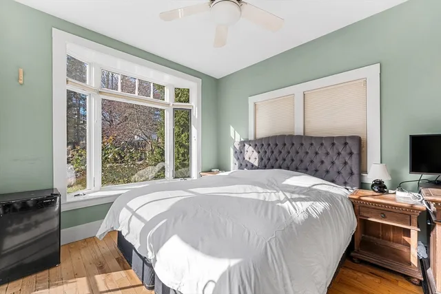 a bedroom with a bed wooden floor and window