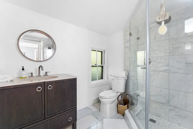 a bathroom with a toilet a sink and mirror