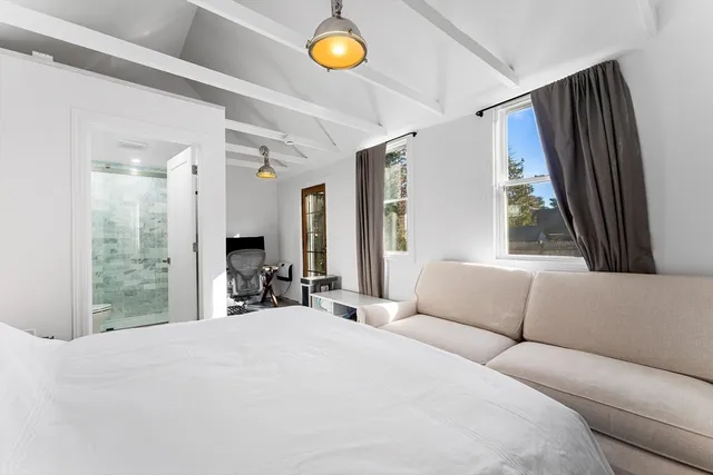 a bedroom with a bed and a large window