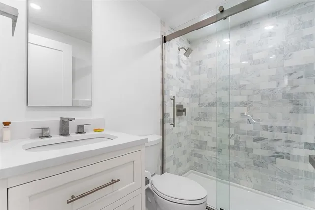 a bathroom with a sink a toilet and shower