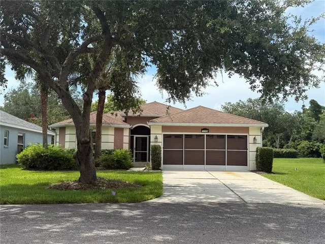 a front view of a house with a garden and trees