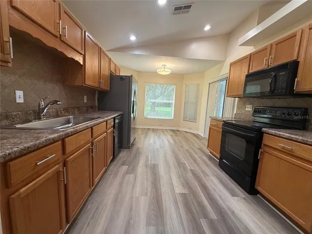 a kitchen with stainless steel appliances granite countertop a sink stove and refrigerator