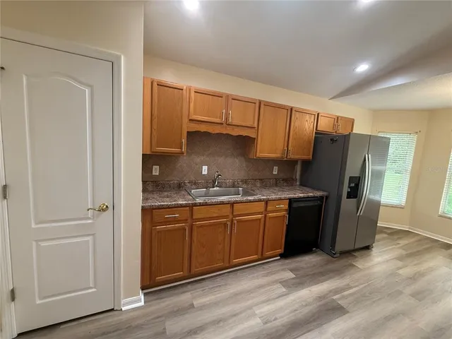 a kitchen with stainless steel appliances granite countertop a refrigerator and a sink