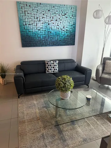 a living room with couches rug and a table