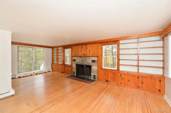 wooden floor fireplace and windows in an empty room