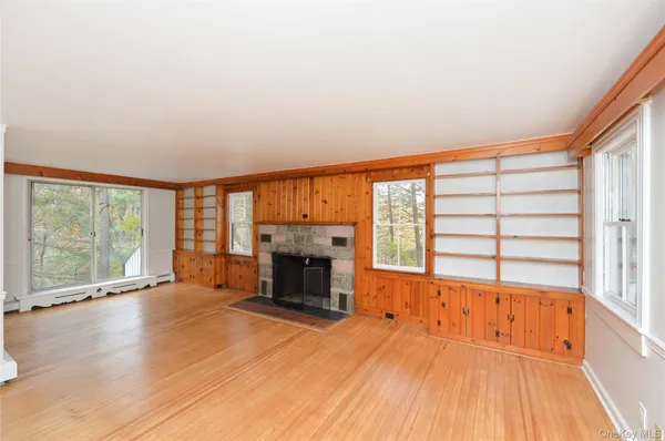 wooden floor fireplace and windows in an empty room