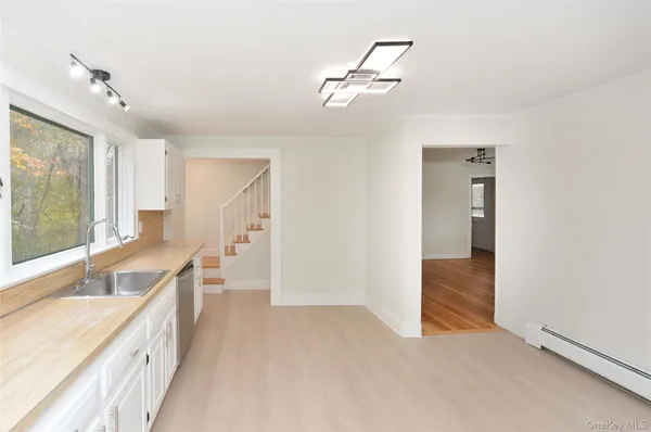 a view of a kitchen with a sink and dishwasher with wooden floor