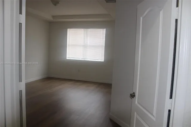 a view of a small space with wooden floor and a window