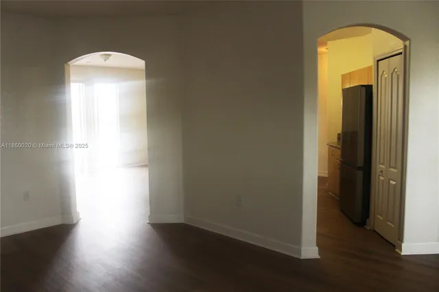 an empty room with wooden floor and a window