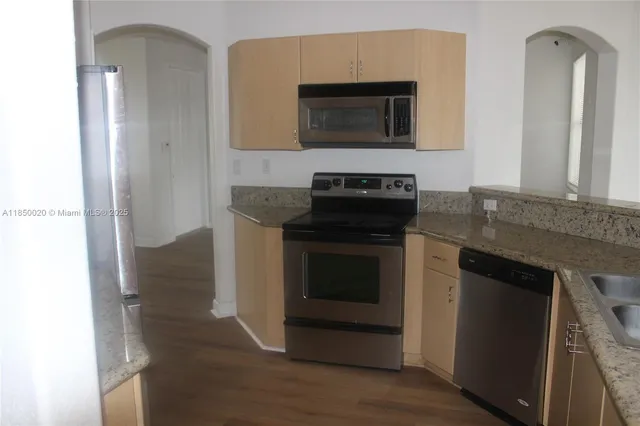 a kitchen with granite countertop a stove and a microwave