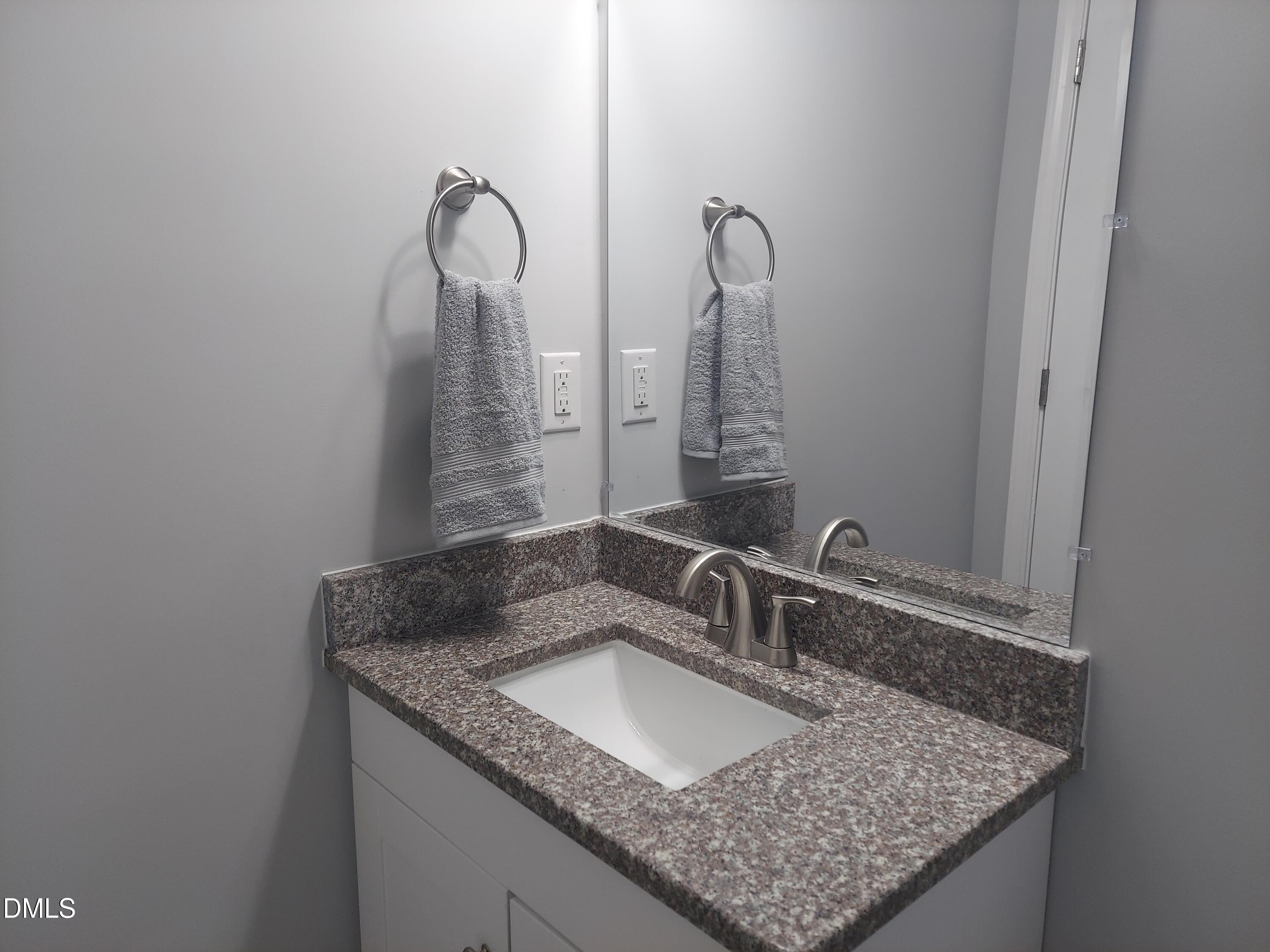 408 Timpson Avenue Durham, NC 27703 - Photo 6 of 14 a bathroom with a granite countertop sink and a mirror