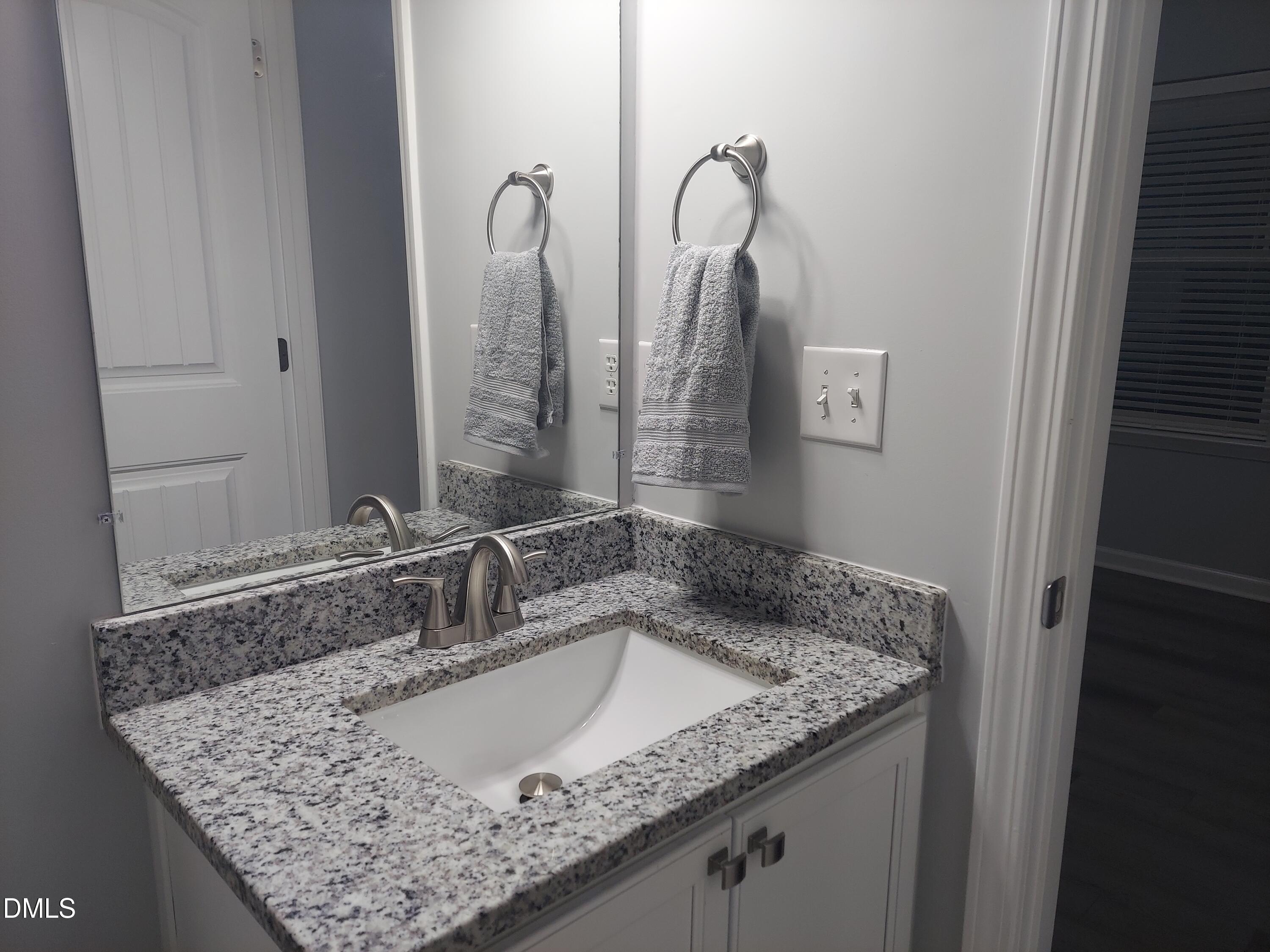 408 Timpson Avenue Durham, NC 27703 - Photo 10 of 14 a bathroom with a granite countertop sink and a mirror