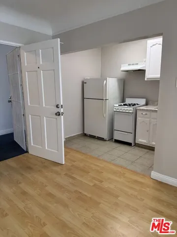 a kitchen with granite countertop a refrigerator and a stove top oven