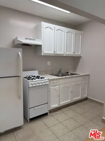 a kitchen with granite countertop a sink and a stove