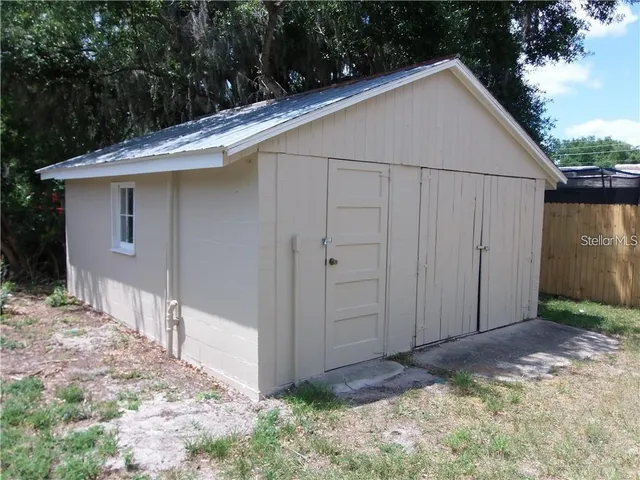 a view of a small house with wooden fence