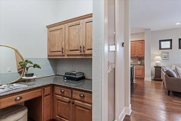 a kitchen with granite countertop a sink a stove and cabinets