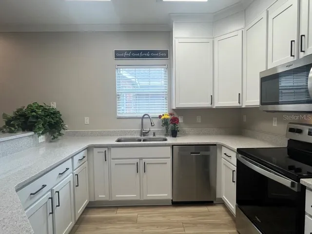 a kitchen with granite countertop a sink stainless steel appliances and cabinets