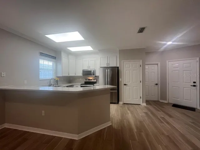 a kitchen with white cabinets and sink