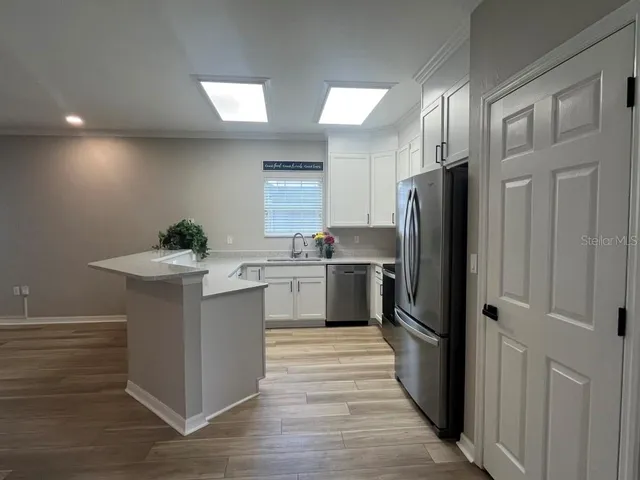 a kitchen with stainless steel appliances a refrigerator sink and stove