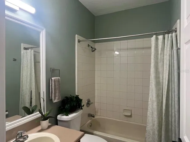 a bathroom with a shower a toilet and a sink