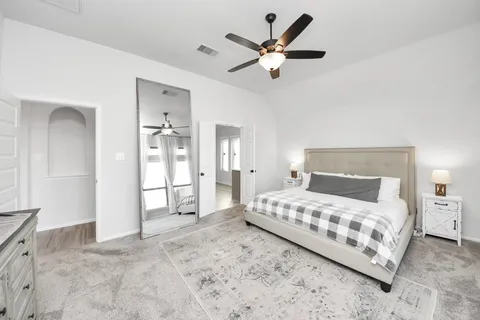 a bedroom with a large bed and a chandelier