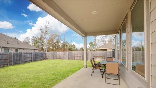 a view of a chair and table in backyard of the house