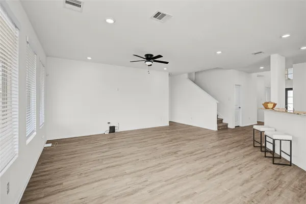 a view of a room with wooden floor and a ceiling fan