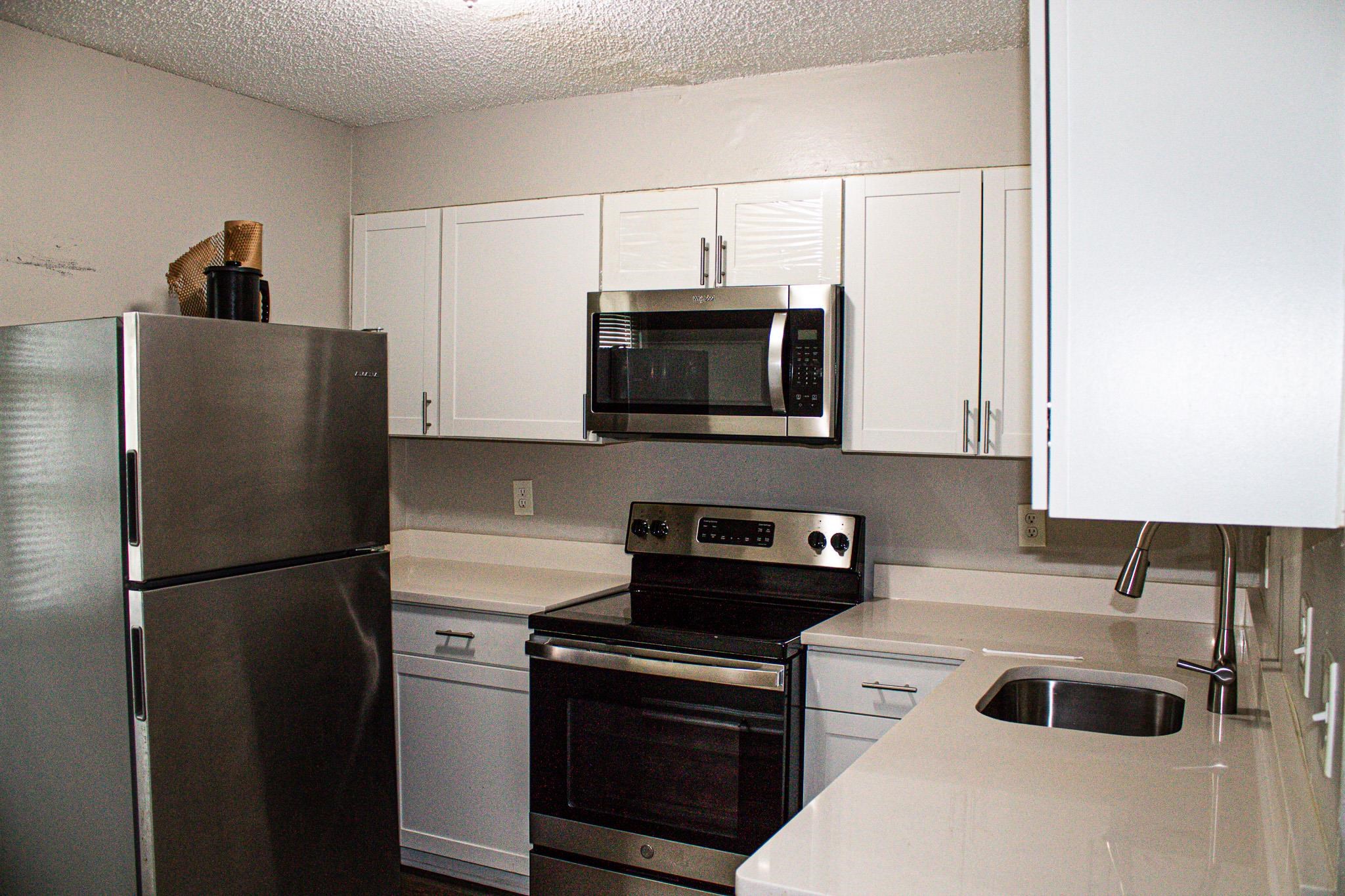 3592 Christine Road Memphis, TN 38118 - Photo 4 of 13 Kitchen featuring white cabinetry, stainless steel appliances, light-toned countertops, and an undermount sink with a gooseneck faucet