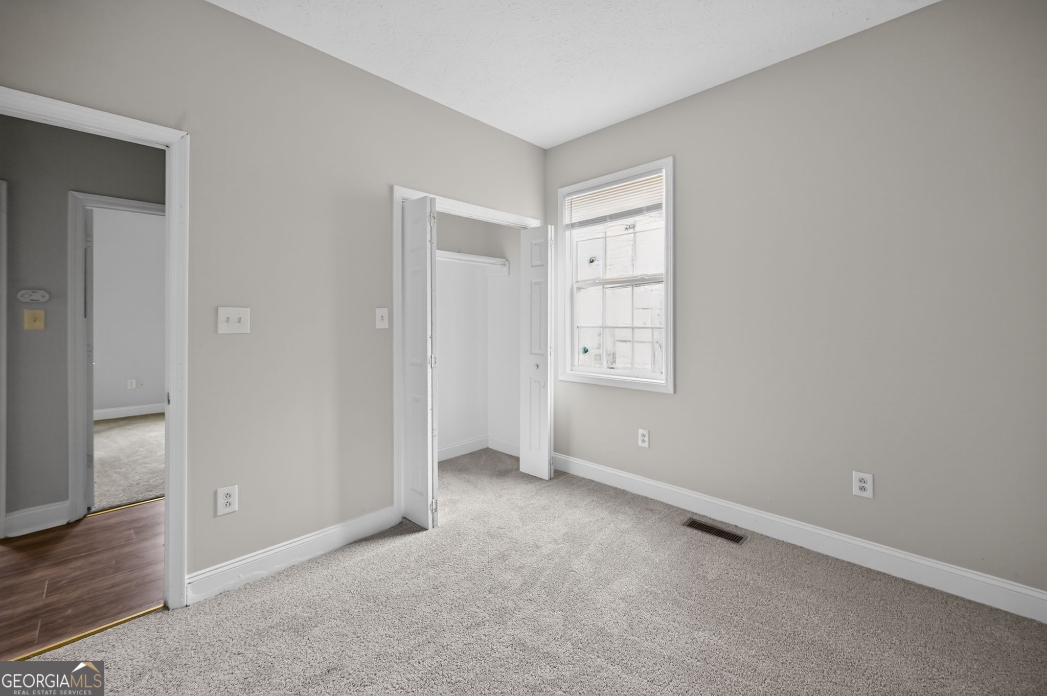 607 Lane Street Griffin, GA 30223 - Photo 18 of 31 an empty room with wooden floor closet and windows