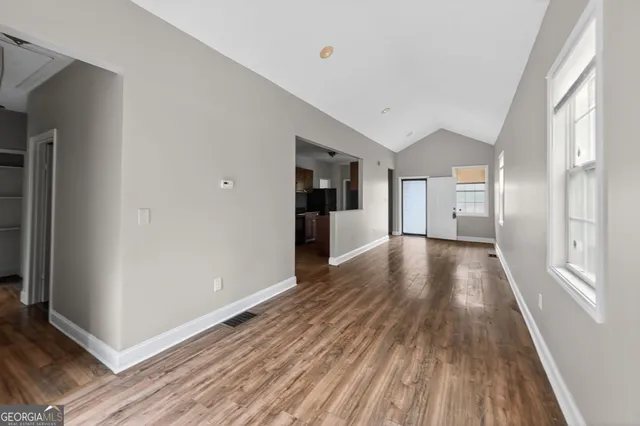 a view of a big room with wooden floor and windows