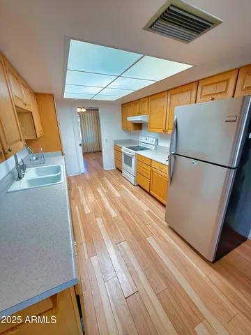 a kitchen with sink refrigerator and microwave