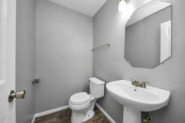 a bathroom with a sink a toilet and mirror