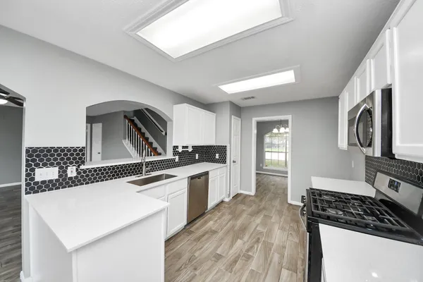 a kitchen with granite countertop a sink stove and refrigerator