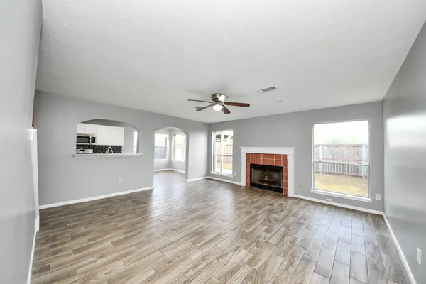 an empty room with windows and fireplace