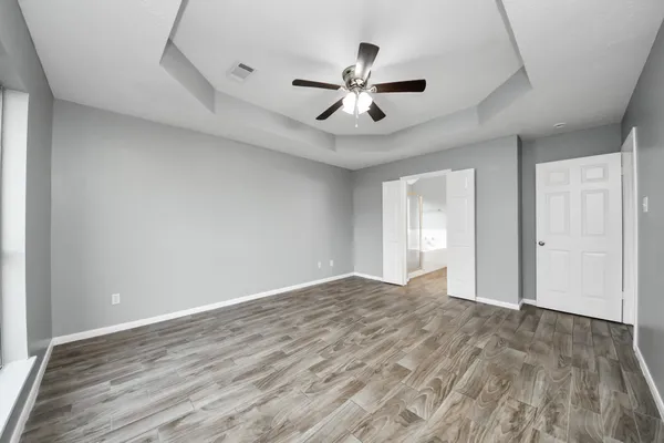 a view of empty room with wooden floor