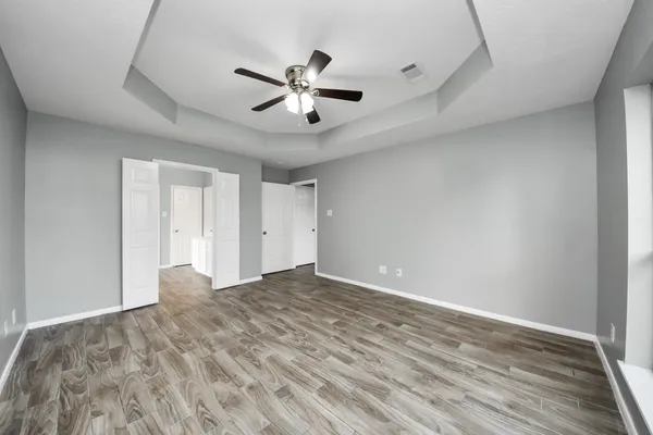 a view of an empty room with a chandelier fan