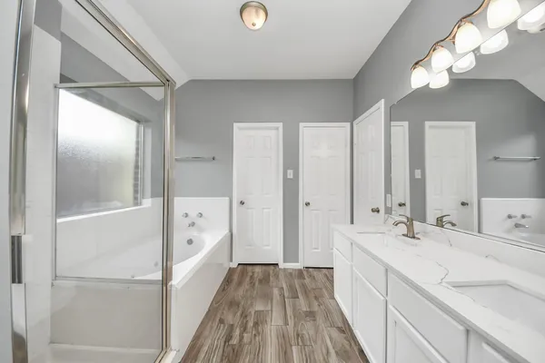 a spacious bathroom with a bathtub sink and mirror