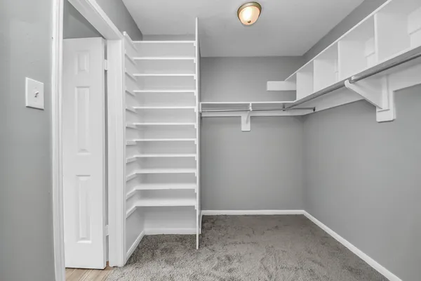 a view of walk in closet with empty racks
