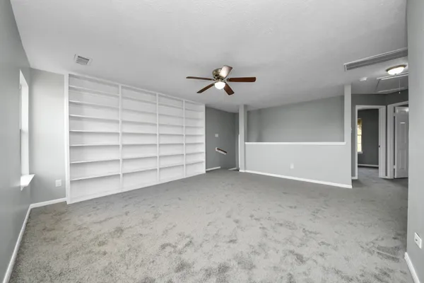 a view of an empty room with a ceiling fan